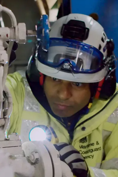 MCA Survey and Inspection team member holding a torch and inspecting part of a ship