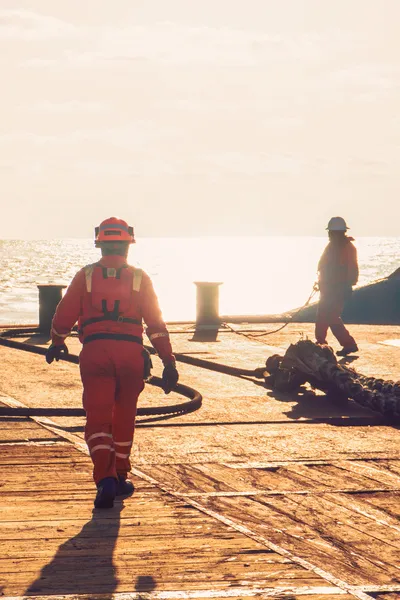Seafarers working on a vessel at sunset