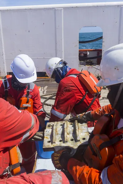 Seafarers on deck installing an anchor panel
