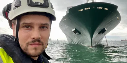 Bart Lubecki, a Senior Surveyor in front of a vessel