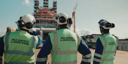 Three MCA surveyors looking at ship