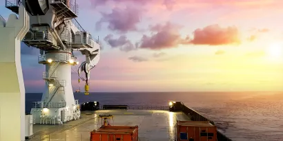 Deck of ship with pink sky in the background