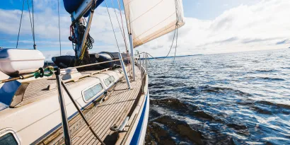 Sloop rigged modern yacht with wooden teak deck on the water