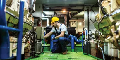 Mechanic repairing an engine inside a ship