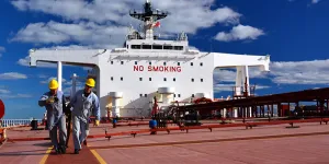 Two seafarers on a red and white ship