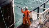 A seafarer cleaning part of the ship
