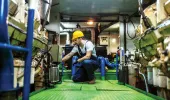 Mechanic repairing an engine inside a ship
